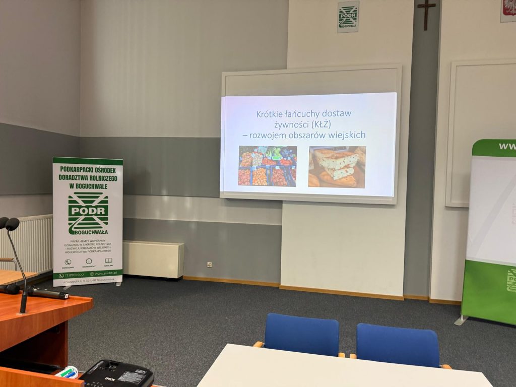 Sala konferencyjna Podkarpackiego Ośrodka Doradztwa Rolniczego w Boguchwale z wyświetloną tytułową strona prezentacji pod tytułem Krótkie łańcuchy dostaw żywności, rozwojem obszarów wiejskich