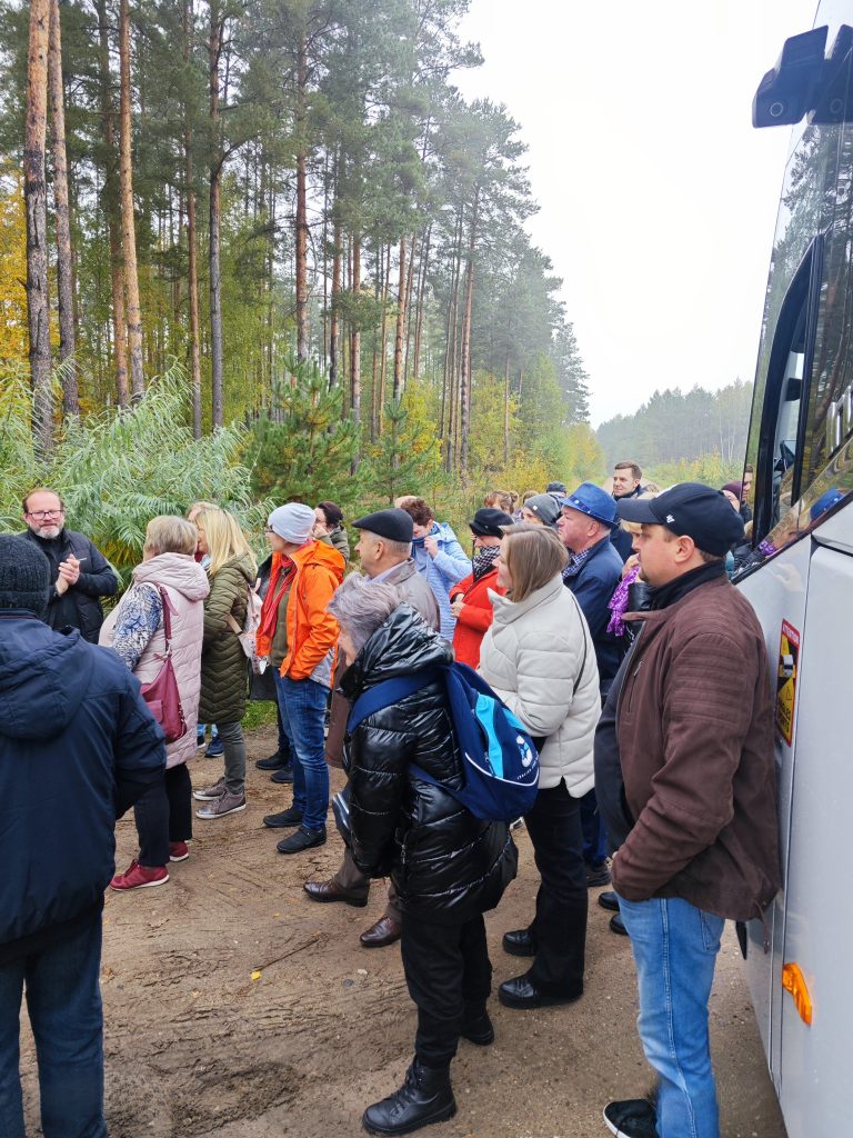 Uczestnicy wyjazdu studyjnego pod nazwą „Gospodarstwa ekologiczne” na Podlasie stoją przy autokarze przed gospodarstwem „Pod Lasem” w Koźlikach. Grupę wita właściciel gospodarstwa.