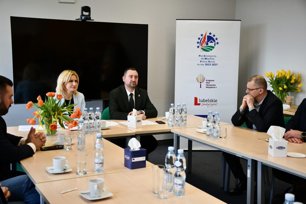 Wicemarszałek Województwa Lubelskiego Marek Wojciechowski wraz z członkami Grupy Roboczej do spraw Rolnictwa siedzą za stołami i trwa rozmowa.